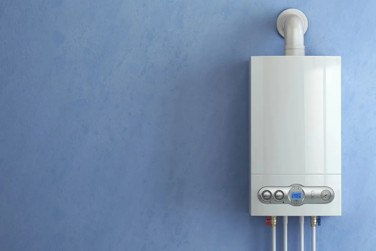 Chauffagiste contrôlant une chaudière murale gaz lors d'un entretien